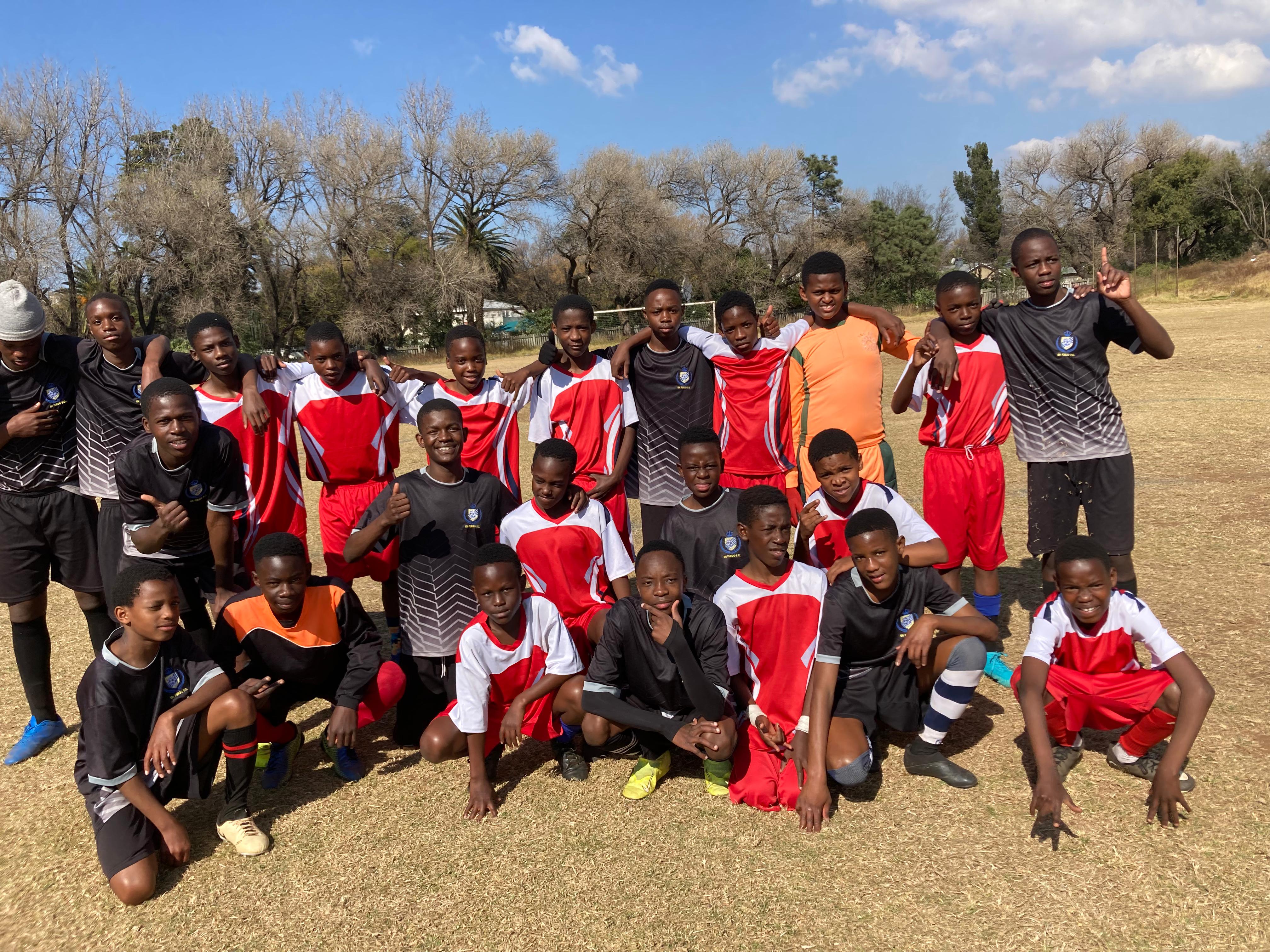 En Fuego FC youth football squad gathered
                    together on the field